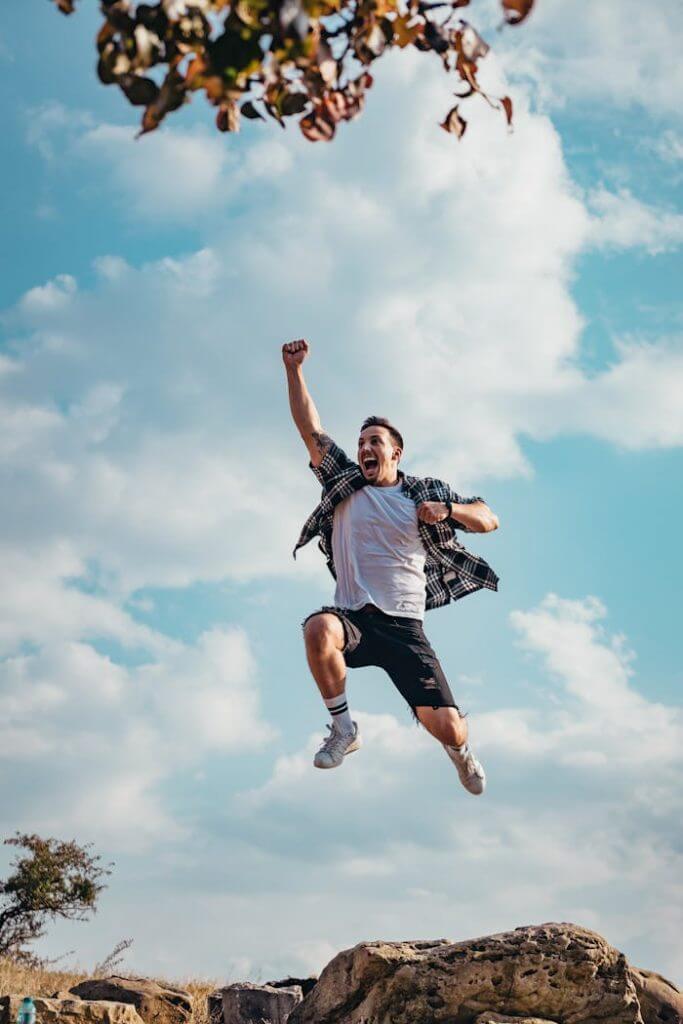pexels-photo-2923157 A vibrant image of a young man jumping with joy outdoors, capturing a moment of freedom and exhilaration.