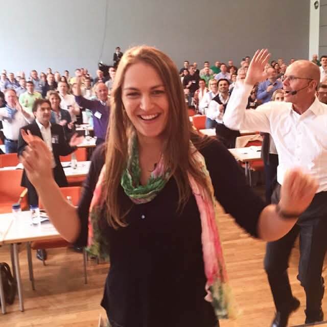 Woman speaking on stage at a personal development seminar — symbolising the growth journey toward emotional clarity, leadership, and cognitive reframing mastery.
