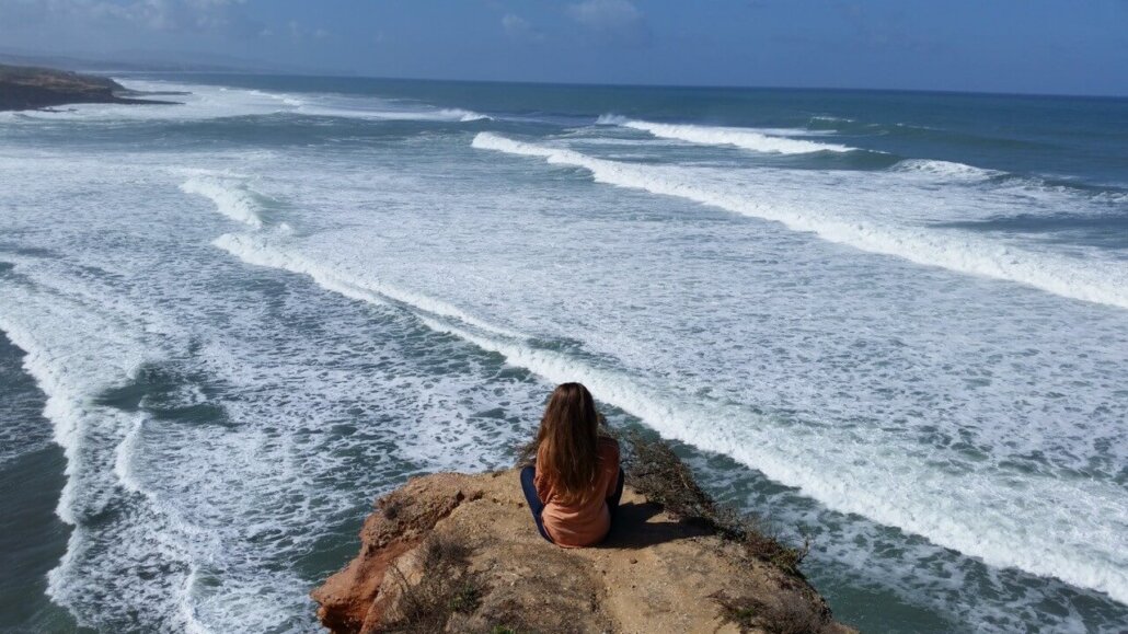 Woman meditating above the ocean, symbolising emotional clarity and authentic resourcefulness through mindfulness