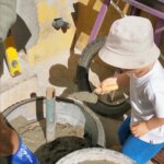 A father and young son pour concrete into an old tire, beginning a hands-on family project to build an umbrella base.