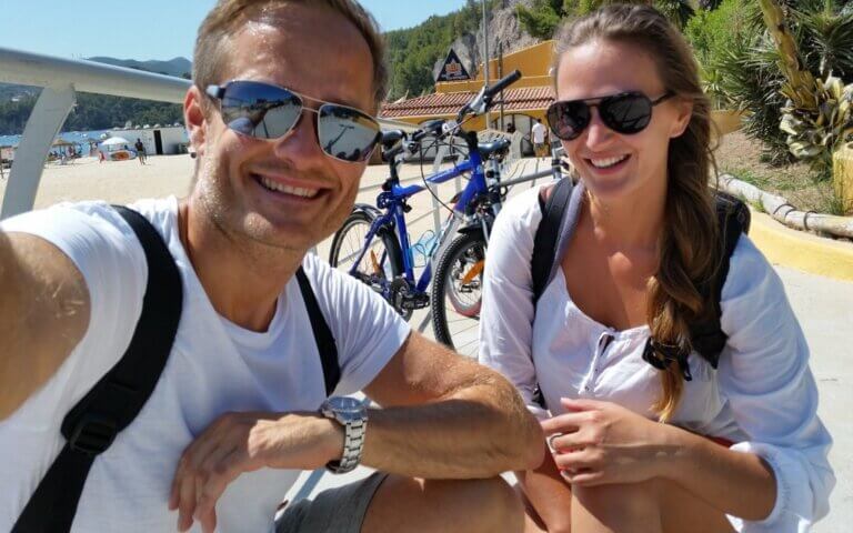 Couple enjoying beach and bike life, reflecting emotional resilience and mindful happiness habits after a breakthrough
